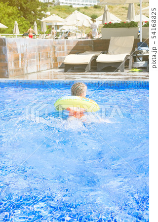 Pretty little girl with blue hair swimming with circle in outdoor pool and have a fun Pretty little girl with blue hair swimming with circle in outdoor pool and have a fun 54168825