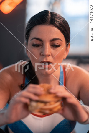 Dark-haired woman working on weight loss dreaming about burger Dark-haired woman working on weight loss dreaming about burger 54171072