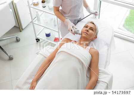 Serious mature woman receiving a dermadrop TDA procedure 54173697