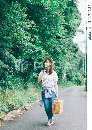 田舎道を歩く女性の写真素材