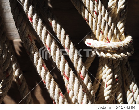 Large white rope hung on the wall. Rope background 54174384