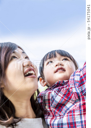 青空を背景にお母さんと上を見つめる幼い女の子。幸福,希望イメージ 青空を背景にお母さんと上を見つめる幼い女の子。幸福,希望イメージ 54175041