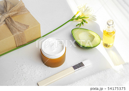 Beauty concept avocado, skin care facial essence oil, brush, lily flower and towel on white 54175375