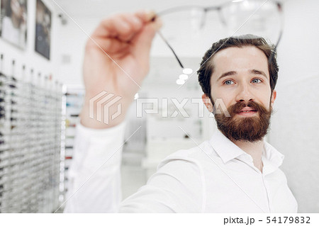 Handsome man in a optics shop Handsome man in a optics shop 54179832