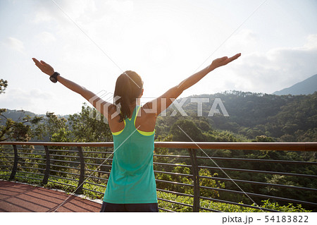 Woman runner outstretched arms on spring morning 54183822