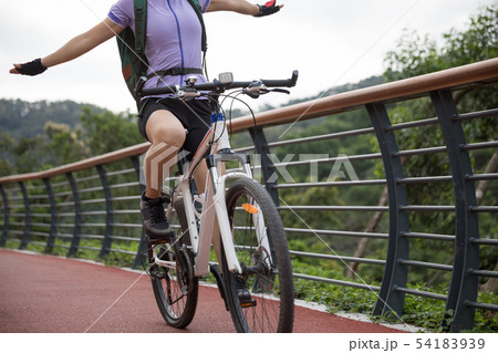 Hands free woman cyclist riding mountain bike on Hands free woman cyclist riding mountain bike on 54183939