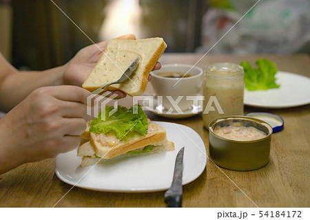 hands spreading tuna mayonnaise on bread for hands spreading tuna mayonnaise on bread for 54184172