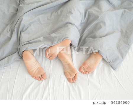 Feet of couple side by side in bed 54184600