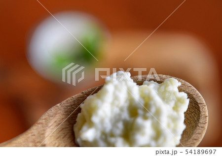 Close-up shot of a wooden spoon full of Kefir 54189697