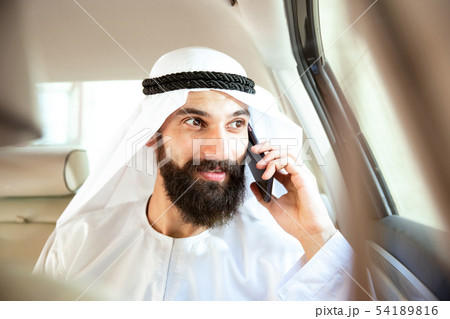 Arabian saudi businessman working in his car 54189816