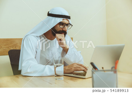 Arabian saudi businessman working in office Arabian saudi businessman working in office 54189913