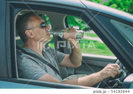 Man drinking alcohol while driving a car 54192644