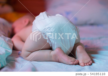 child lying on his stomach. a little boy in a diaper sleeping booty up. resting child. day sleep 54195110