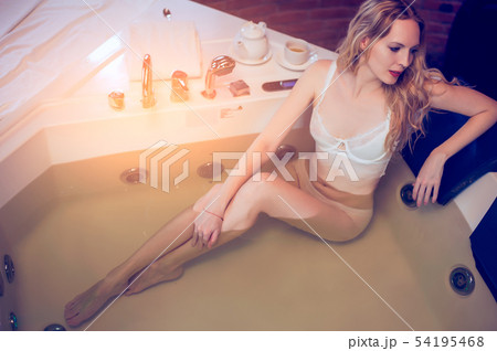 Beautiful slender blonde in a spa cabin sits in a 54195468