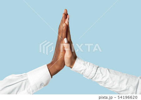 Two male hands shaking isolated on blue studio background 54196620