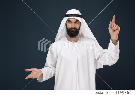 Arabian saudi man on dark blue studio background Arabian saudi man on dark blue studio background 54199360