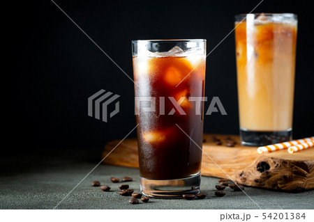Ice coffee in a tall glass with cream poured over. 54201384