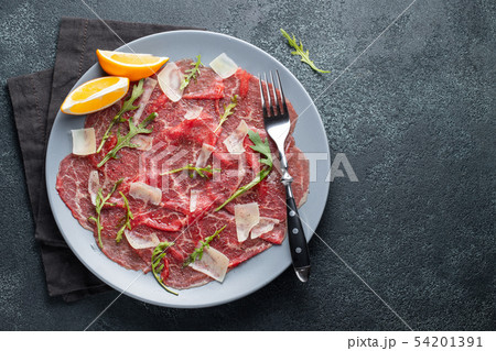 Marbled beef carpaccio with arugula. 54201391