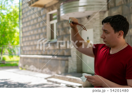 The man in the street rubs his glasses The man in the street rubs his glasses 54201480