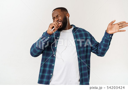 Handsome Afro American man in casual clothes is listening to music using a smart phone and smiling. 54203424