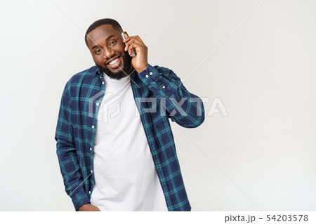Young black man smiling and talking on mobile phone. 54203578