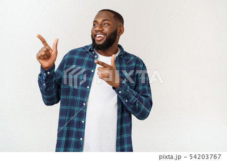 Happy delighted male fore finger at blank copy space, wears denim shirt, has positive smile 54203767