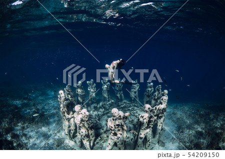 Woman free diver with underwater statues. Woman free diver with underwater statues. 54209150