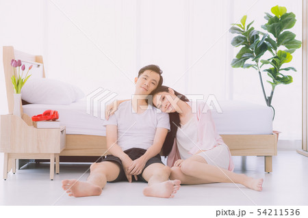Sexy couple in pajamas sit on floor in bedroom.. 54211536