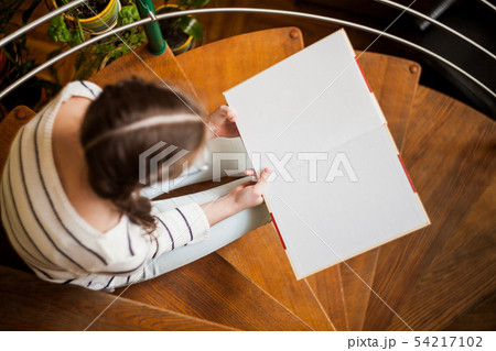 The girl on the stairs reading a book The girl on the stairs reading a book 54217102