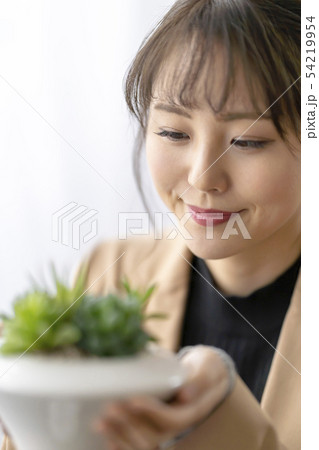 多肉植物ハオルチアオブツーサの葉の透明感が美しい窓と呼ばれる先端部分を眺める笑顔が癒される女性 多肉植物ハオルチアオブツーサの葉の透明感が美しい窓と呼ばれる先端部分を眺める笑顔が癒される女性 54219954