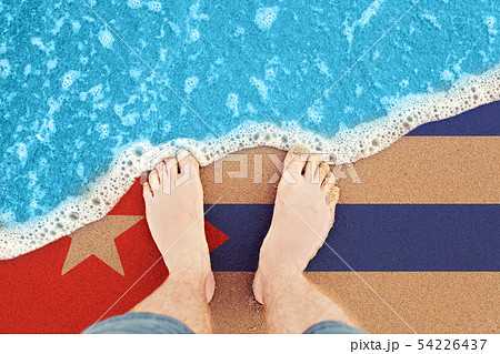 Two feet on sandy beach with flag Cuba. Top View Two feet on sandy beach with flag Cuba. Top View 54226437