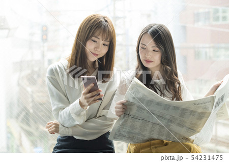 窓辺でスマホと新聞を見る女性二人 窓辺でスマホと新聞を見る女性二人 54231475