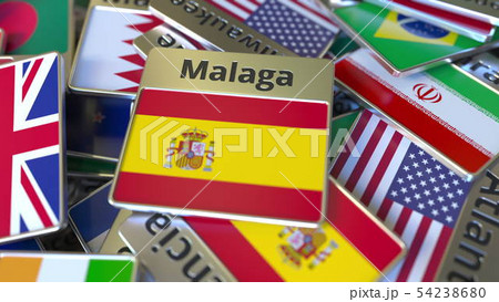 Souvenir magnet or badge with Malaga text and national flag among different ones. Traveling to Spain 54238680