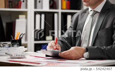 Businessman working and calculating, reads and 54242407