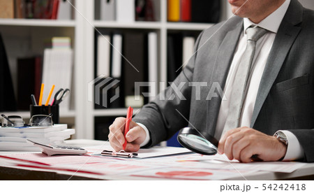 Businessman working and calculating, reads and 54242418