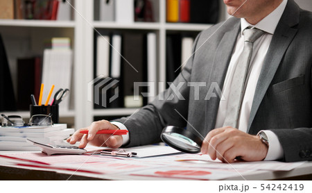 Businessman working and calculating, reads and 54242419