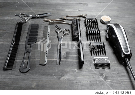 Set of professional hairdresser tools on grey background. Wooden table in barbershop. Working tool Set of professional hairdresser tools on grey background. Wooden table in barbershop. Working tool 54242963