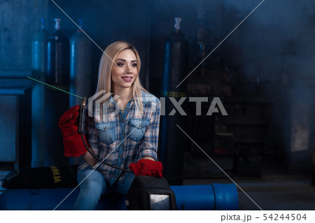 Girl with a welding machine. girl in a blue shirt Girl with a welding machine. girl in a blue shirt 54244504