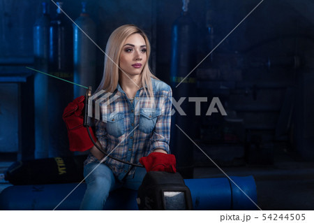 Girl with a welding machine. girl in a blue shirt 54244505