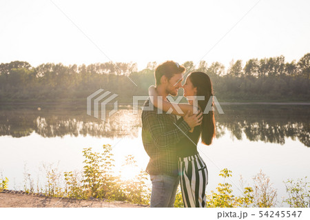 People, love and nature concept - Young beautiful woman and handsome man embracing each other over 54245547