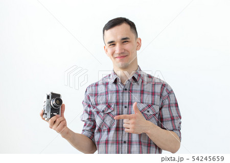 Vintage, photographer and people concept - handsome asian man with retro camera over white Vintage, photographer and people concept - handsome asian man with retro camera over white 54245659