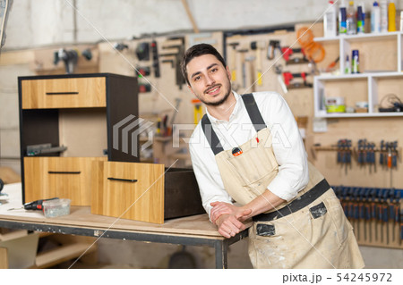 furniture factory, Small-Sized Companies and people concept - Portrait of a smiling male worker at furniture factory, Small-Sized Companies and people concept - Portrait of a smiling male worker at 54245972
