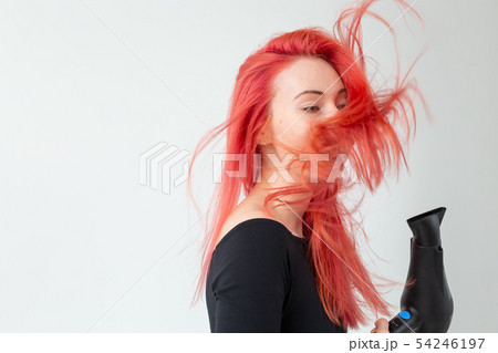 Hairdresser, beauty salon and people concept - young woman hair stylist with hair dryer on white 54246197
