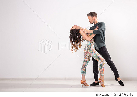 Social dance, bachata, kizomba, tango, salsa, people concept - Young couple dancing over white Social dance, bachata, kizomba, tango, salsa, people concept - Young couple dancing over white 54246546