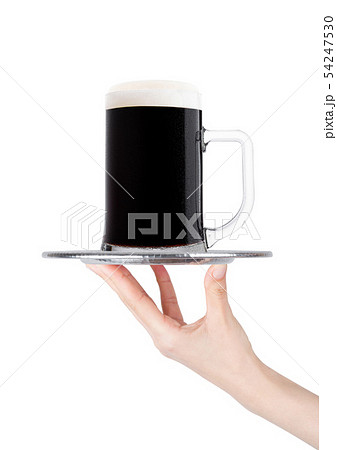 Hand holds tray with cold stout dark beer with dew 54247530