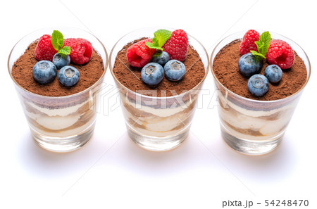 Classic tiramisu dessert with blueberries and raspberries in a glass isolated on a white background Classic tiramisu dessert with blueberries and raspberries in a glass isolated on a white background 54248470
