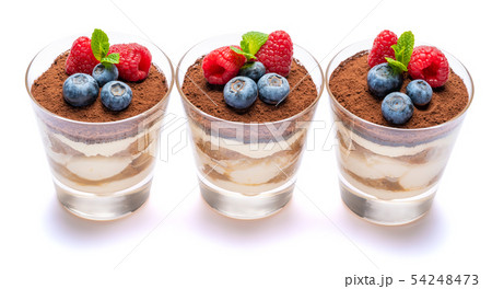 Classic tiramisu dessert with blueberries and raspberries in a glass isolated on a white background Classic tiramisu dessert with blueberries and raspberries in a glass isolated on a white background 54248473
