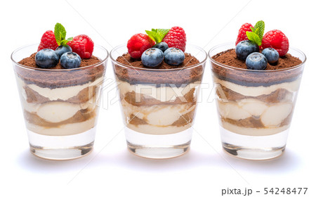 Classic tiramisu dessert with blueberries and raspberries in a glass isolated on a white background Classic tiramisu dessert with blueberries and raspberries in a glass isolated on a white background 54248477