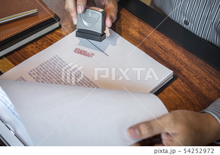 Hands of businessman stamp on paper document to 54252972