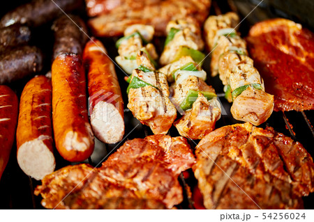 Different types of juicy meats on hot coals on grill in garden Different types of juicy meats on hot coals on grill in garden 54256024